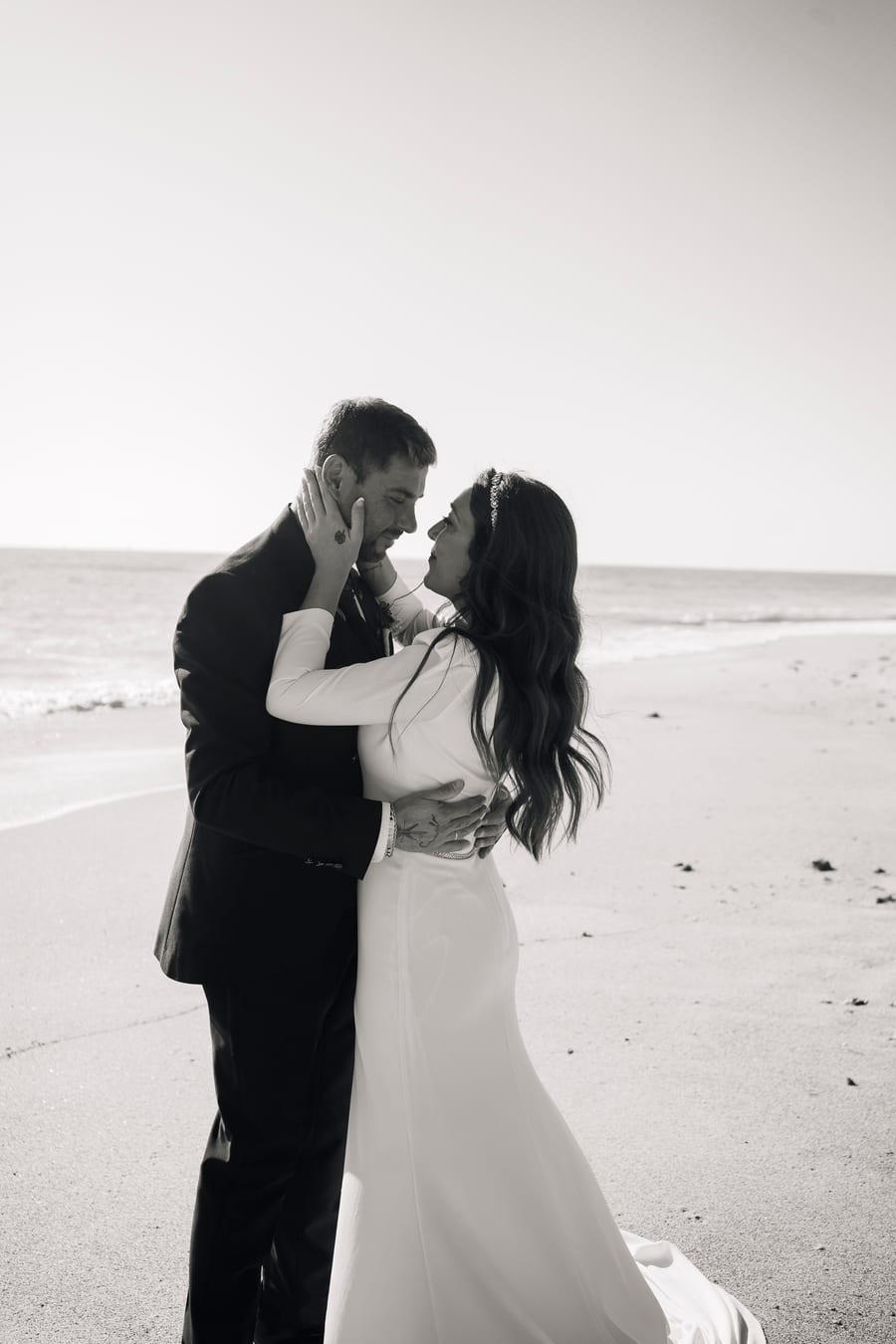 Couple embracing on the beach, in black and white