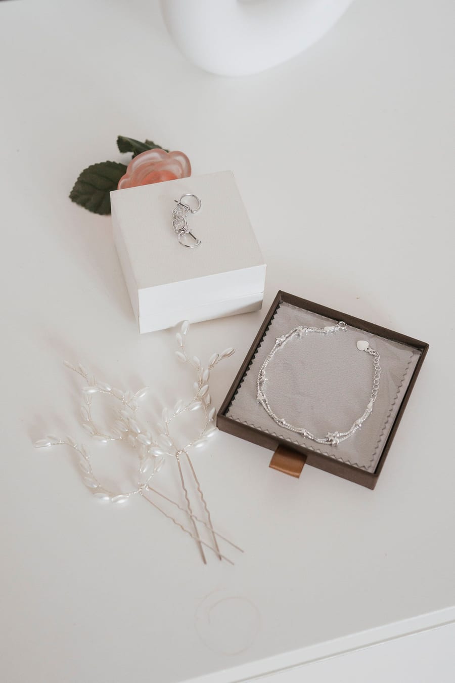 Bride's jewelry and perfume on a marble table