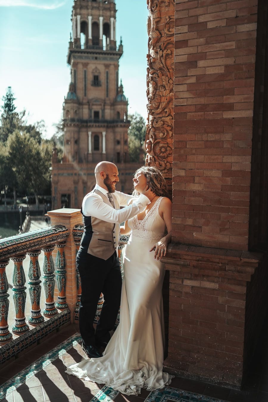 Couple embracing in a brick and tile gallery in Seville