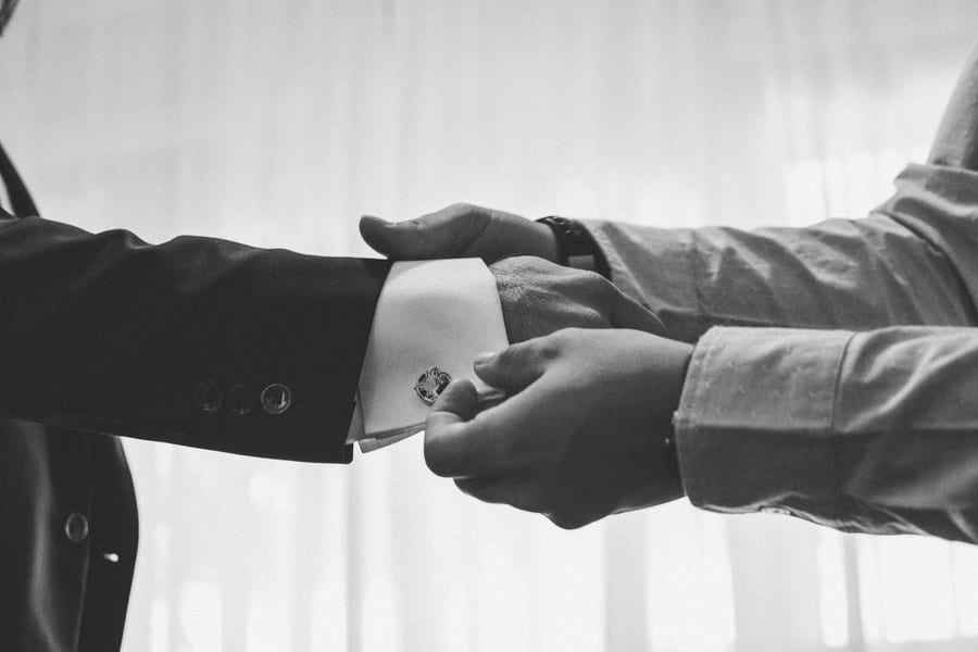Groom's cufflinks as he adjusts his suit