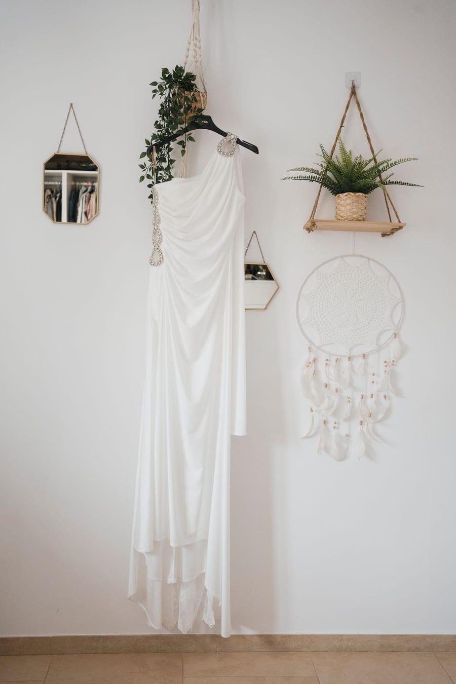 Wedding dress hanging in a bright room with handmade decor