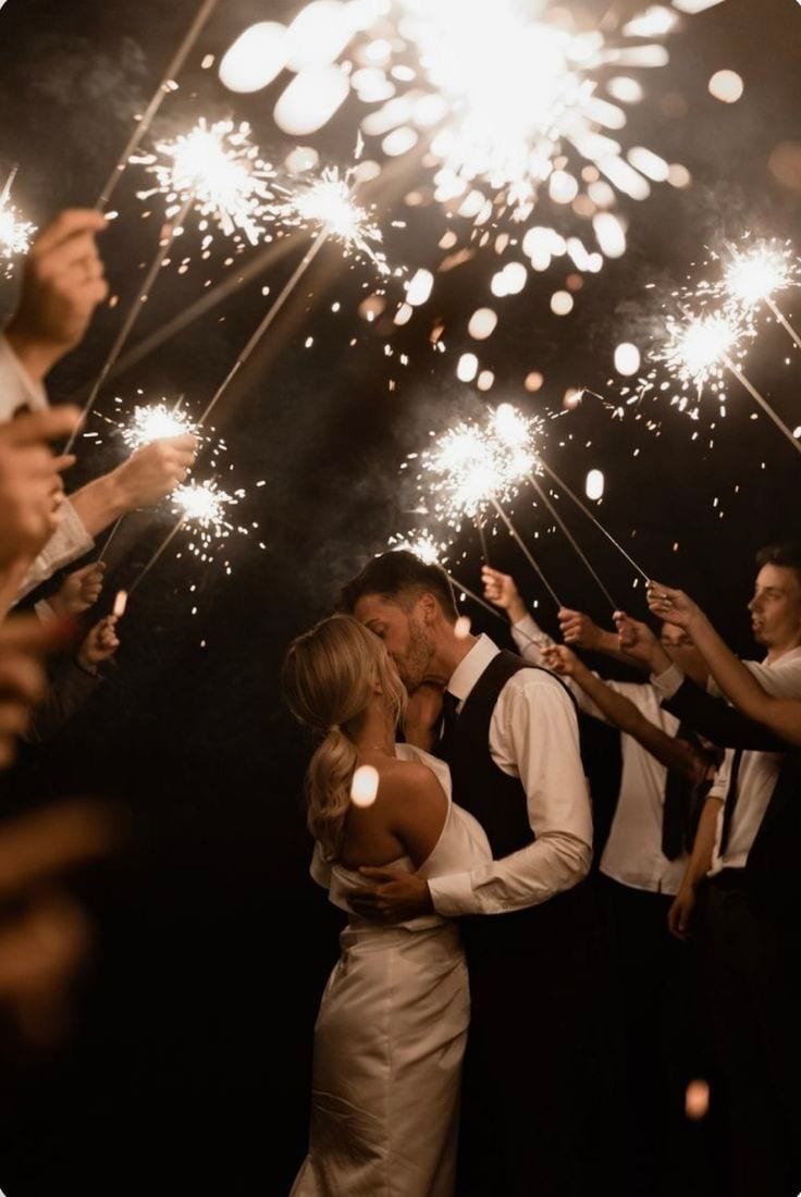 Couple kissing surrounded by sparklers on their wedding night